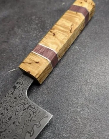 Manche en bois clair avec inserts bordeaux, monté sur un couteau de cuisine